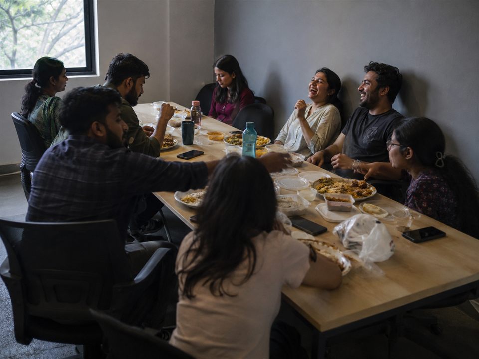 The team sharing lunch together around a long table, laughing