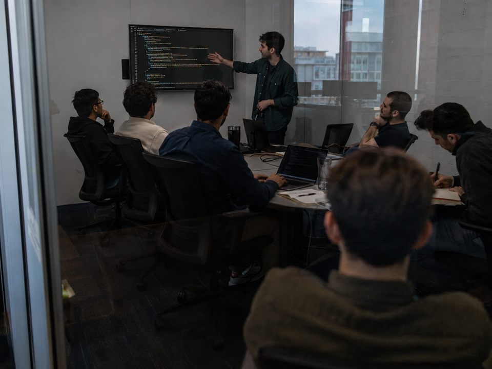 A young engineer presenting their work to the team in a meeting room